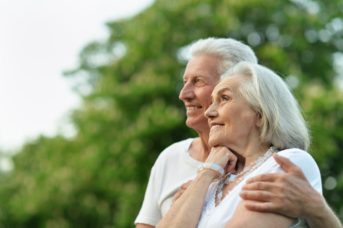 two elderly people looking happily into the distance