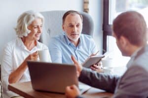 Two elderly people signing final expense life insurance policy